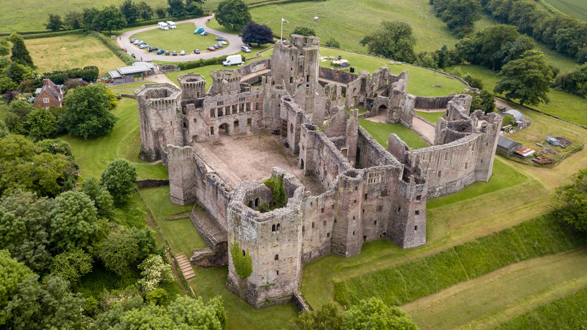 Aerial view of Raglan Castle and courtyard, with grassy surroundings