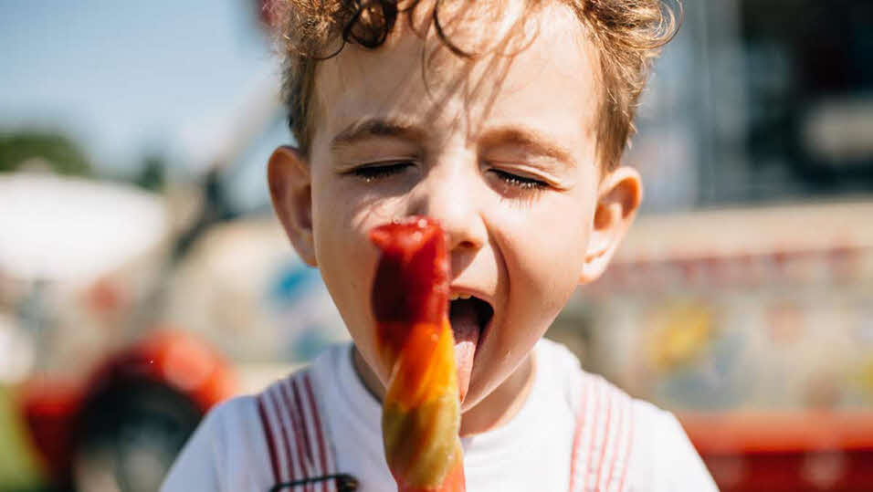 Young boy eating an ice lolly